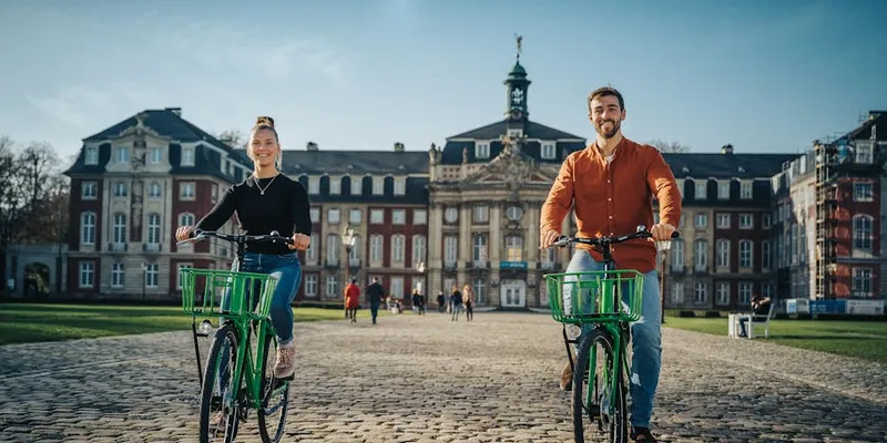 Aasee in Münster mit Segelbooten und Fahrradfahrern bei Sonnenuntergang