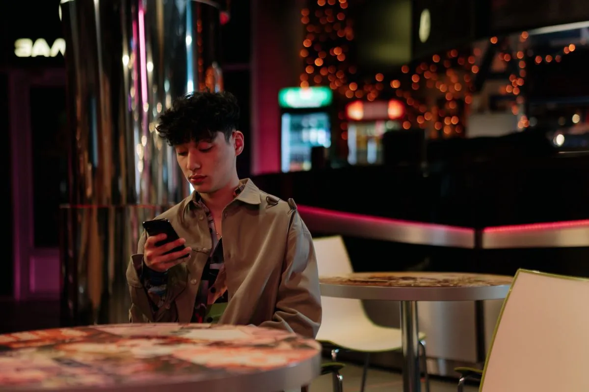 Symbolbild diskretes Dating — Person tippt nachts am Smartphone