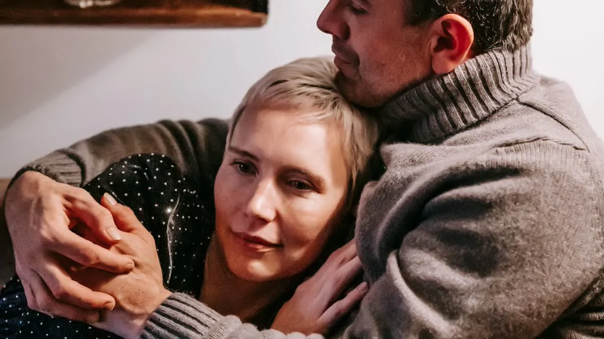 Paar umarmt sich innig auf einem Sofa in warmem Abendlicht