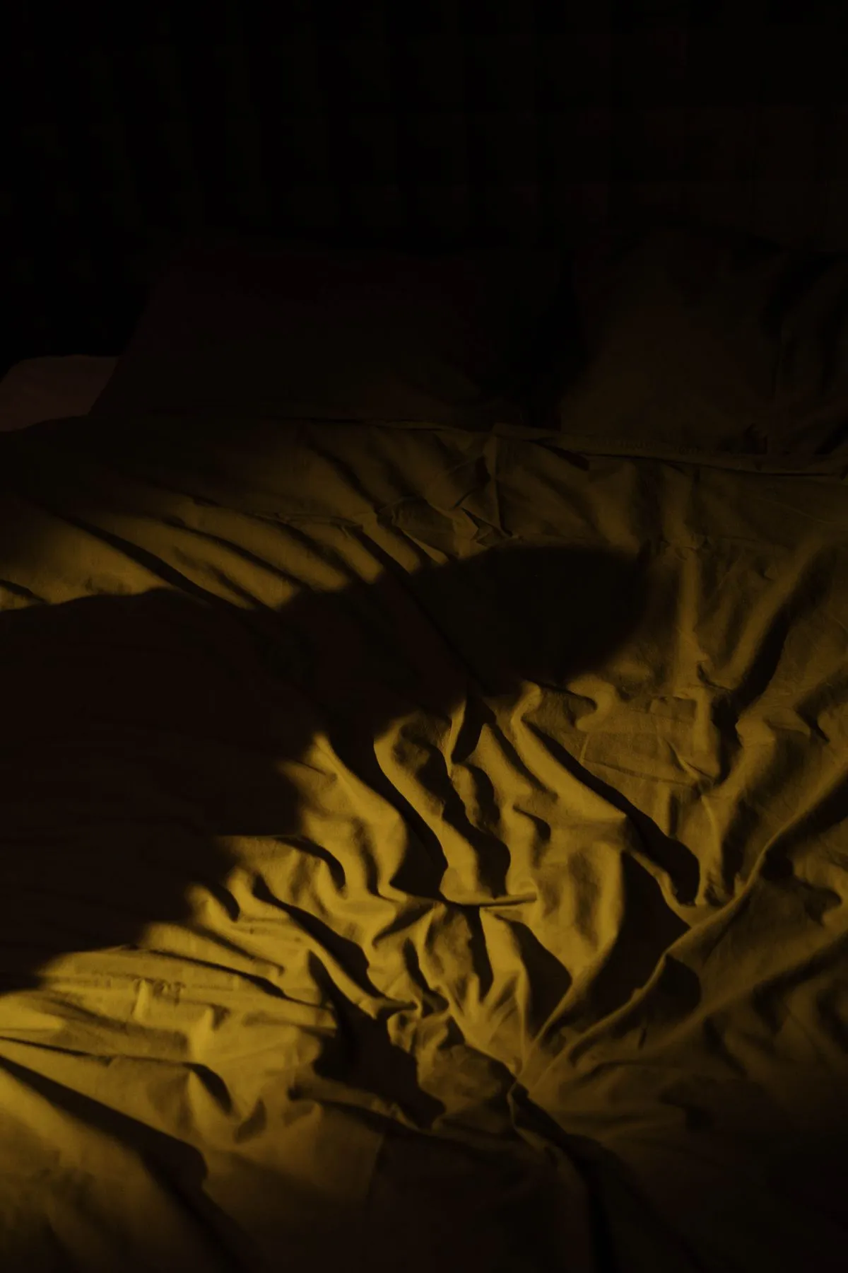 Zerwühltes Bett im Morgenlicht — Symbolbild für unruhigen Schlaf und Albträume