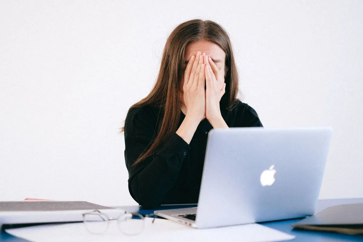 Person mit müdem, unkonzentriertem Blick am Schreibtisch — Symbolbild Brain Fog
