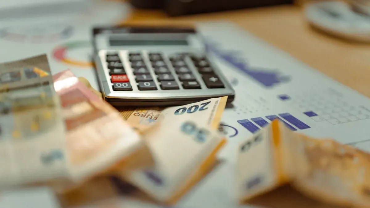 Euro-Banknoten und ein Taschenrechner auf Finanzunterlagen