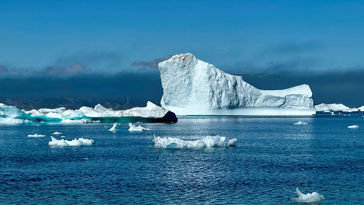 Ein Eisberg im Meer, dessen kleine sichtbare Spitze über der Wasserlinie und dessen weit größere Masse unter Wasser zu sehen ist