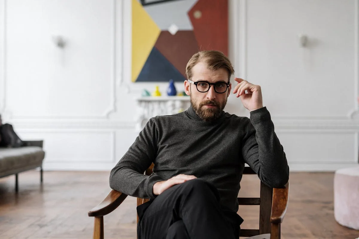 Mann mit Brille in Therapieumgebung reflektiert über emotionale Vernachlässigung