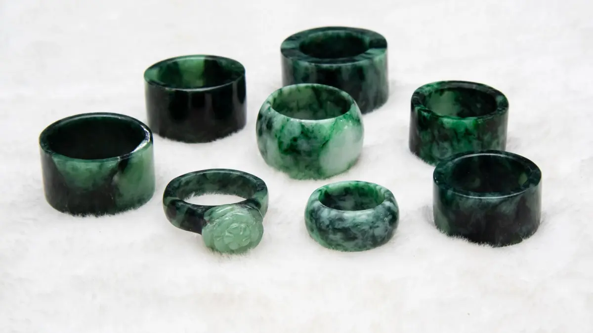 Acht Ringe aus grün gemaserter Jade auf weißem Fell