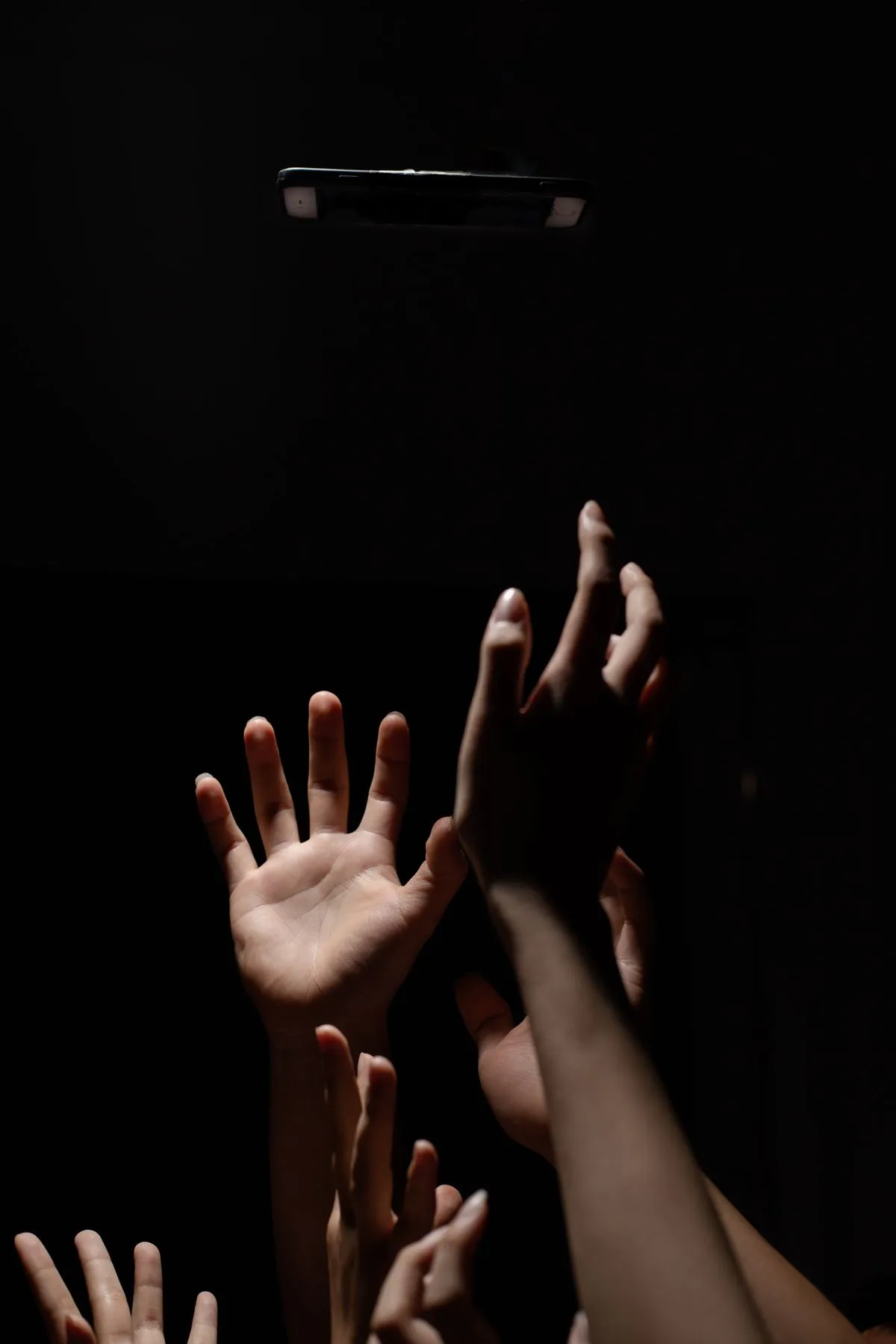 Hand greift angespannt nach einem Smartphone auf dem Tisch — Symbolbild Nomophobie