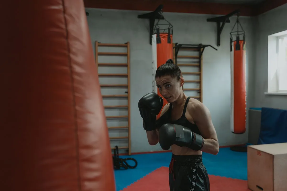 Frau mit Boxhandschuhen trainiert konzentriert in einem Boxstudio