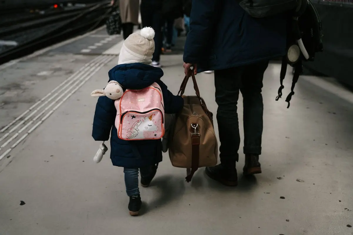 Kind mit Rucksack zwischen zwei Wohnungstüren