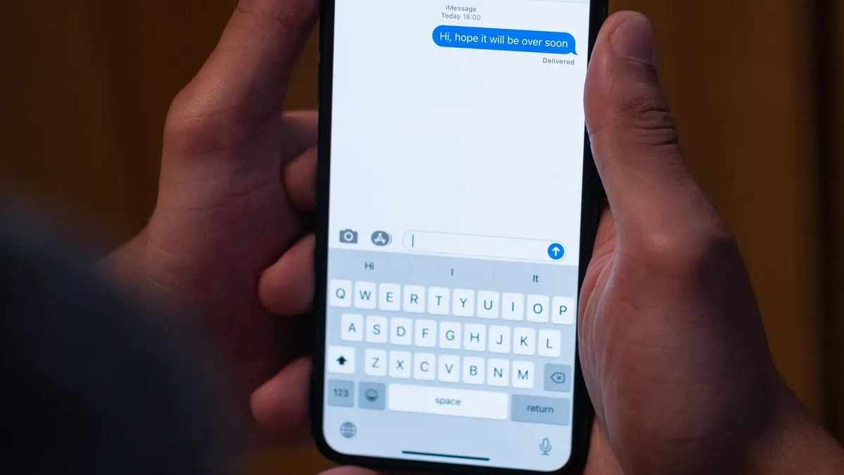 Zwei Hände halten ein Smartphone mit geöffnetem Chat und einer zugestellten Nachricht